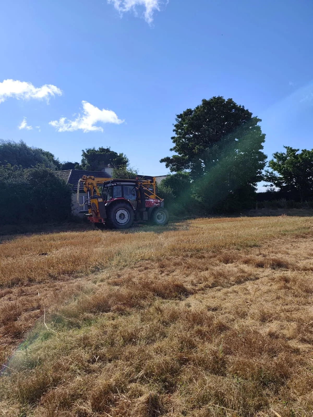 Tractor and flail equipment cutting rough grass on accessible ground