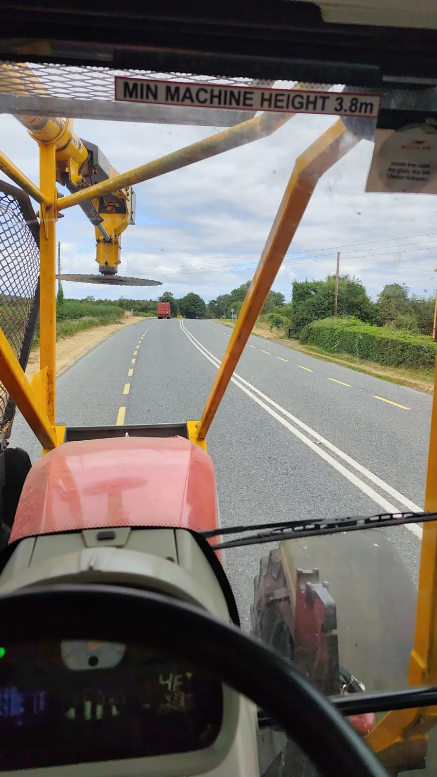 Tractor carrying out roadside hedge cutting
